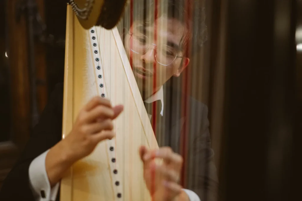 Aasia päritolu härrasmees mängib harfi