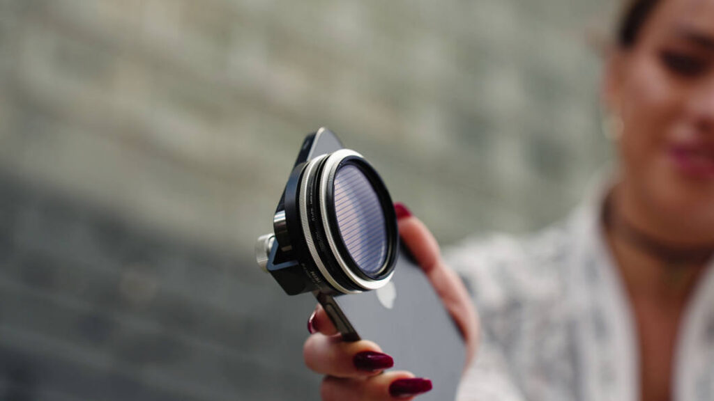 NiSi Smartphone Filter on iPhone nutitelefoni ees ja seda hoiab naisterahvas.