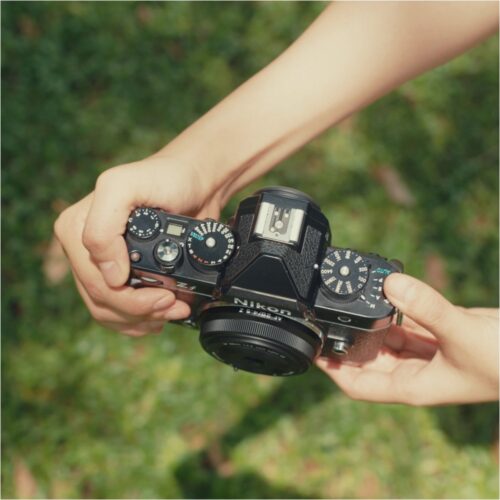 Inimene hoiab käes Nikon Zf kaamerat, mille ette on kinnitatud Viltrox AF 28mm f/4.5