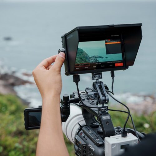 Viltrox DC-A1 7" Super Bright Monitor – inimene tööd tegemas tootega mere ääres