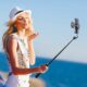 kübaraga naine saadab õhusuudluse Ulanzi AB403 selfipulgal olevale nutitelefonile