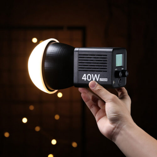 Ulanzi LT028 40W LED-videovalgusti käes hoituna, soe valgus pimedas stuudios