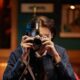 Fotograaf pildistab retrokaameraga, mille peal on Godox Lux Junior II